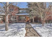 Charming two-story brick home with a snow-covered front yard and a welcoming pathway at 2038 S Columbine St, Denver, CO 80210