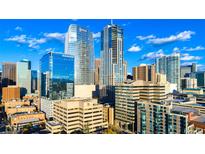 Stunning cityscape view with modern glass buildings against a bright blue sky with scattered clouds at 1133 14Th St # 4150, Denver, CO 80202