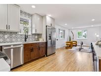 Open concept kitchen showcasing a large island, sleek countertops, and stainless steel appliances, perfect for cooking and entertaining at 5573 S Huron St, Littleton, CO 80120
