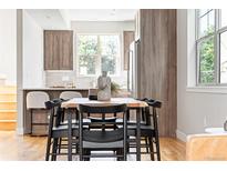 Modern dining area with a long wooden table and black chairs at 2828 N Federal Blvd, Denver, CO 80211