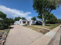 Charming home featuring a long driveway, lush landscaping, and a detached garage at 475 Tennyson St, Denver, CO 80204