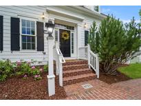 Inviting front entrance featuring brick steps, white railings, and a welcoming wreath on the black front door at 8721 E 23Rd Ave, Denver, CO 80238