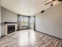 Bright living room featuring a fireplace, hardwood floors, and sliding glass doors at 5745 W Atlantic Pl # 207, Lakewood, CO 80227