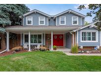 Two-story house with gray siding, red door, and landscaped lawn at 10399 Zenobia Ct, Westminster, CO 80031