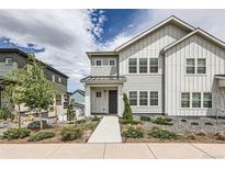 Charming two-story home featuring white siding, landscaped front yard, and inviting walkway at 8822 Fraser River Loop, Littleton, CO 80125