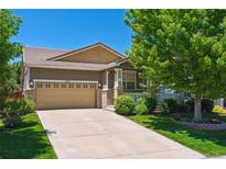 Exterior of a tan two-story home with a two car garage and well manicured lawn at 2741 Poplar Grove Pl, Castle Rock, CO 80109