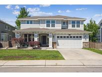 Charming two-story home with a landscaped front yard, covered porch, and a two-car garage at 14049 Detroit Dr, Thornton, CO 80602
