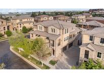 Beautiful multi-story home featuring stone accents, a tile roof, manicured landscaping, and a two-car garage at 3291 Cascina Cir # D, Highlands Ranch, CO 80126