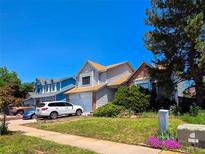 Charming home with well-maintained lawn and mature trees on a sunny day at 20391 E 42Nd Ave, Denver, CO 80249