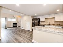 Open-concept kitchen with white cabinetry, stainless steel appliances, and granite countertops at 17004 E Tennessee Dr # 212, Aurora, CO 80017