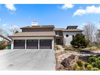 Charming home showcasing a three-car garage, tile roof and well-maintained landscaping at 12017 W 54Th Dr, Arvada, CO 80002