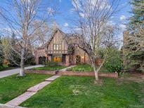 Charming brick Tudor home featuring a beautiful lawn and mature trees at 10 Cherry St, Denver, CO 80220