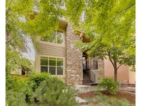 Charming two-story home with a stone facade and a beautifully landscaped front yard at 2940 Ulster St, Denver, CO 80238