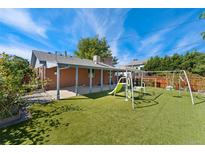 Large backyard features a playset, an outdoor patio, and artificial grass at 2692 S Pennsylvania St, Denver, CO 80210