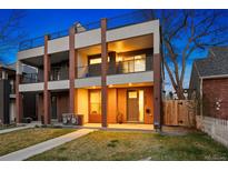 Modern two-story townhome with balconies, brick accents, and a well-manicured lawn at twilight at 3928 Vrain St, Denver, CO 80212