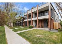 Modern townhomes with striking brick accents, balconies, and well-maintained lawns on a tree-lined street at 3928 Vrain St, Denver, CO 80212