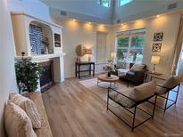 Bright living room with fireplace, hardwood floors, and large windows offering plenty of natural light at 11300 Night Heron Dr, Parker, CO 80134