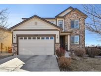 Charming two-story home featuring a stone facade, a two-car garage, and well-maintained landscaping at 22336 E Bellewood Dr, Aurora, CO 80015