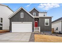 Charming two-story home with a two car garage, red front door, and well-manicured landscaping at 17747 Prairie Peak Trl, Parker, CO 80134