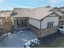 Charming single-Gathering home with stone accents, a covered front porch, and a spacious two-car garage at 17412 W 93Rd Pl, Arvada, CO 80007