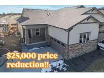 Charming single-Gathering home featuring stone accents, a covered porch, and an attached two-car garage at 17412 W 93Rd Pl, Arvada, CO 80007