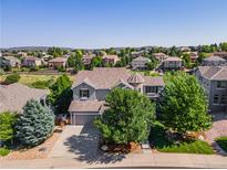 Beautiful gray two-story home featuring mature trees, a turret and an attached two car garage at 2980 Craig Ct, Castle Rock, CO 80109