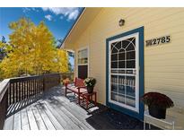 Charming front porch with bench seating, potted flowers, and a welcoming entrance to the home at 2785 Magpie Ln, Larkspur, CO 80118