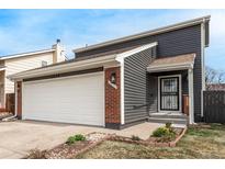 Charming home featuring a two-car garage, red brick accents, and tidy landscaping at 11820 Sherman St, Northglenn, CO 80233