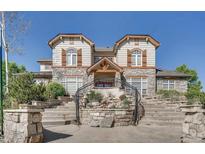A grand exterior view of the stone home with steps leading up to the entrance and well-maintained landscaping at 3252 E 103Rd Dr # 708, Denver, CO 80229
