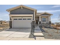 Charming home featuring a two-car garage with stone accents and a welcoming front porch at 423 Basin Daisy St, Castle Rock, CO 80104