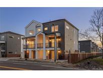 Modern two-story townhome featuring dual balconies, gray and white siding, and well-lit entryways at 4539 Tabor St, Wheat Ridge, CO 80033