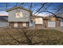 Charming two-story home featuring a brick and siding exterior, attached garage and a well-maintained front yard at 18835 E Utah Cir, Aurora, CO 80017