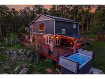 Stunning backyard with a spacious deck, hot tub, and outdoor seating, perfect for relaxing and entertaining at 4574 Picutis Rd, Indian Hills, CO 80454