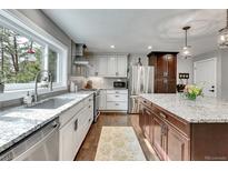 A spacious kitchen boasts granite counters, stainless appliances, light cabinets, and a large island at 4574 Picutis Rd, Indian Hills, CO 80454