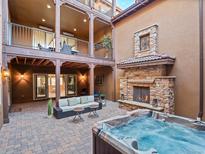 Inviting outdoor courtyard with a stone fireplace, spa, and cozy seating area with balconies at 9355 E Winding Hill Ave, Lone Tree, CO 80124