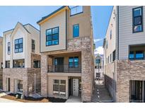 Modern three-story home featuring a brick facade and a second-story balcony at 11475 E Briarwood Cir, Centennial, CO 80112
