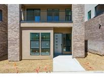 Modern townhouse with a balcony and brick accents at 11475 E Briarwood Cir, Centennial, CO 80112