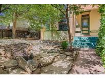 Charming front yard with stone features, lush greenery, and quaint entrance to a well-maintained home at 2227 N Gilpin St, Denver, CO 80205