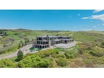 Stunning luxury home on hillside with outdoor living space and fire pit at 3520 Castle Butte Dr, Castle Rock, CO 80109