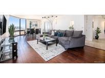 Bright and airy living room with hardwood floors, floor to ceiling windows, and a modern gray sofa at 1625 Larimer St # 2601, Denver, CO 80202