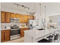 Bright kitchen features stainless steel appliances, a breakfast bar, and stylish pendant lighting at 10176 Park Meadows Dr # 2408, Lone Tree, CO 80124
