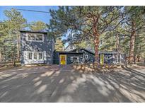 Stylish home with a yellow door and mature trees offering shade and curb appeal at 638 Kinnikinnik Hl, Golden, CO 80401