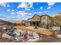 Stunning backyard featuring a stone patio, firepit, and breathtaking mountain views for outdoor enjoyment at 4937 Hogback Ridge Rd, Morrison, CO 80465