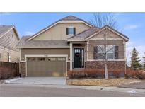 Charming two-story home featuring a stone and siding exterior, a well-manicured lawn, and an attached two-car garage at 9587 Kentwick Cir, Englewood, CO 80112