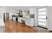 Bright kitchen featuring white cabinets, stainless steel appliances, and hardwood floors at 2175 S Joliet St, Aurora, CO 80014