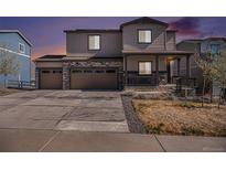 Charming two-story home featuring a stone facade, three-car garage, and covered front porch at 2243 Villageview Ln, Castle Rock, CO 80104