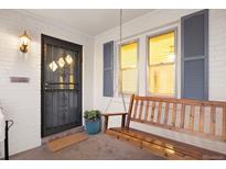 Inviting front porch with a charming porch swing and a secure, decorative metal screen door at 1901 S Lincoln St, Denver, CO 80210