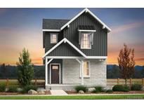 Charming two-story home featuring vertical siding and stone accents, set against a picturesque sunset backdrop at 23782 E 33Rd Pl, Aurora, CO 80019