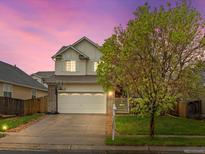 Charming two-story home boasts a well-maintained lawn, a basketball hoop and a two car garage at 4436 Windmill Dr, Brighton, CO 80601