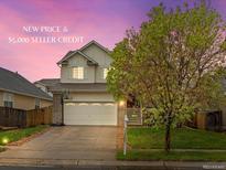 Inviting two-story home with a well-manicured lawn, two-car garage, and a basketball hoop on the driveway at 4436 Windmill Dr, Brighton, CO 80601